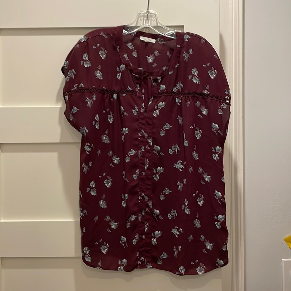 Pleione burgundy short sleeve top with flowers.